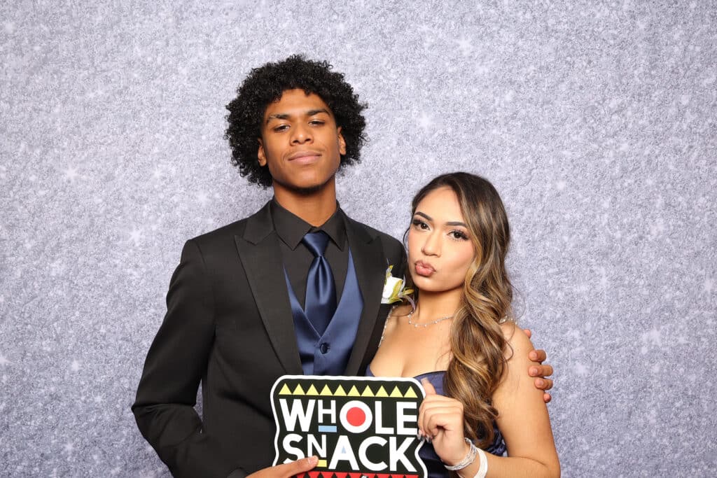 Guests enjoying fun moments and taking pictures at a high school prom event.