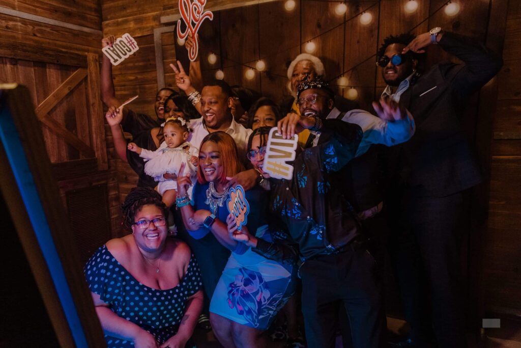 Guests celebrating and posing at a Paparazzi-themed event photo booth.