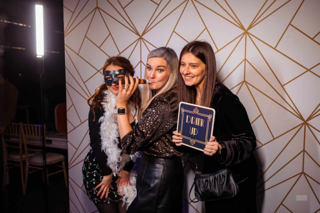 Event attendees capturing fun moments at a Paparazzi-themed photo booth.