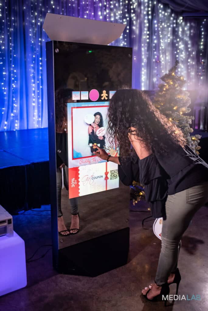 Attendees interacting with a Magic Mirror Booth during a corporate or party event.