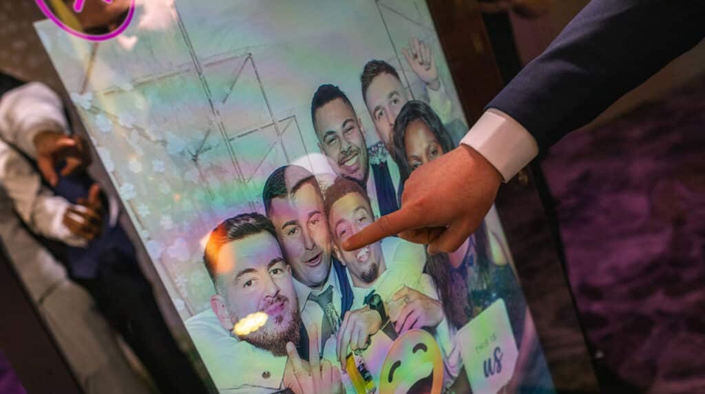 Attendees enjoying the Magic Mirror Booth with fun poses and event-themed props.