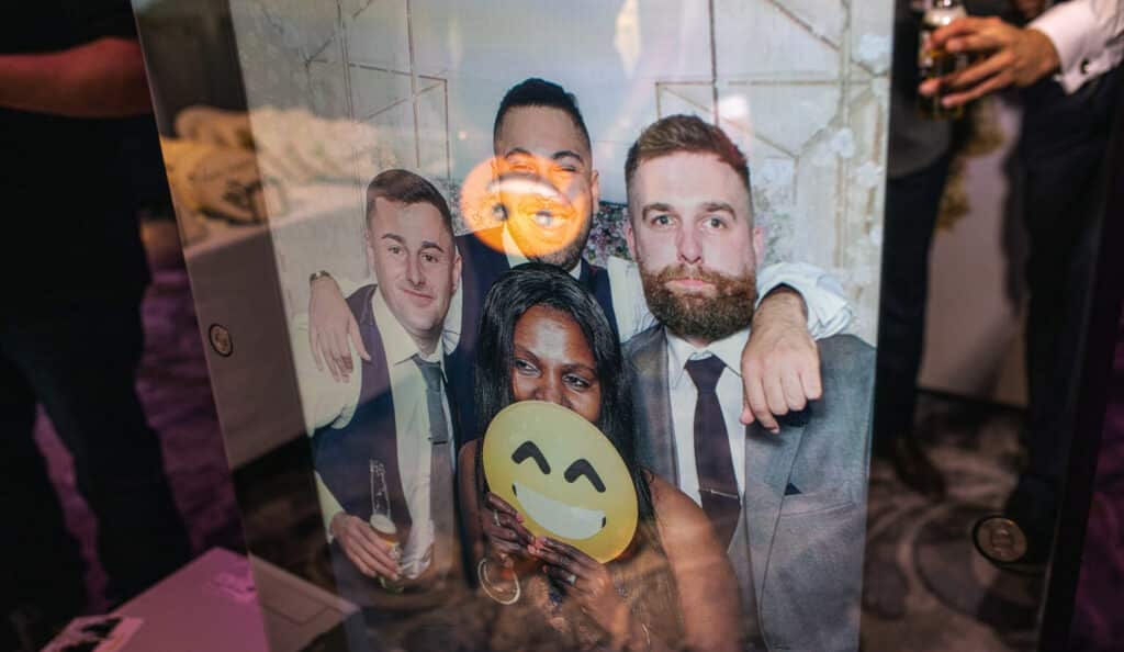 Guests taking interactive photos at a Magic Mirror Booth during a wedding, party, or corporate event.