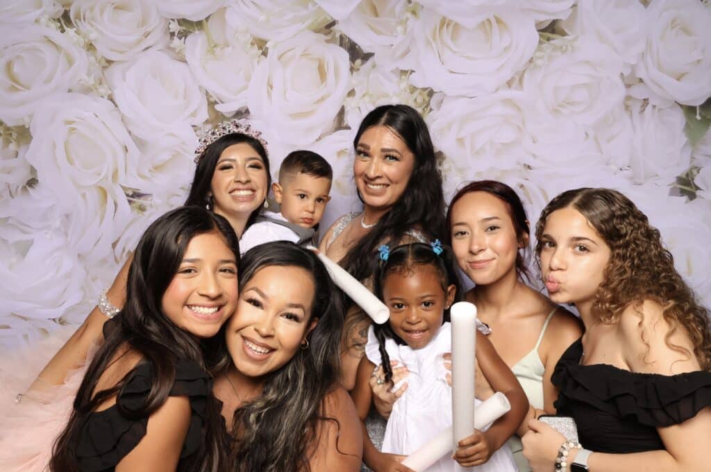 Guests posing for photos during a festive Quinceañera event.