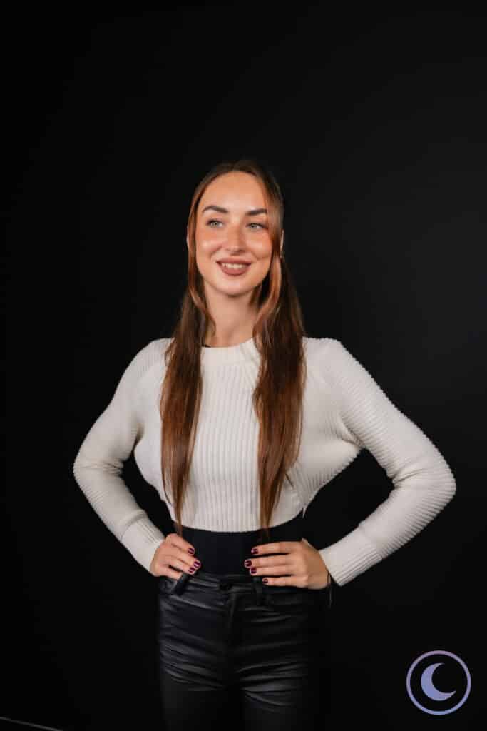 Studio headshot of woman in white sweater on black background captured by Luna Events Headshot Booth