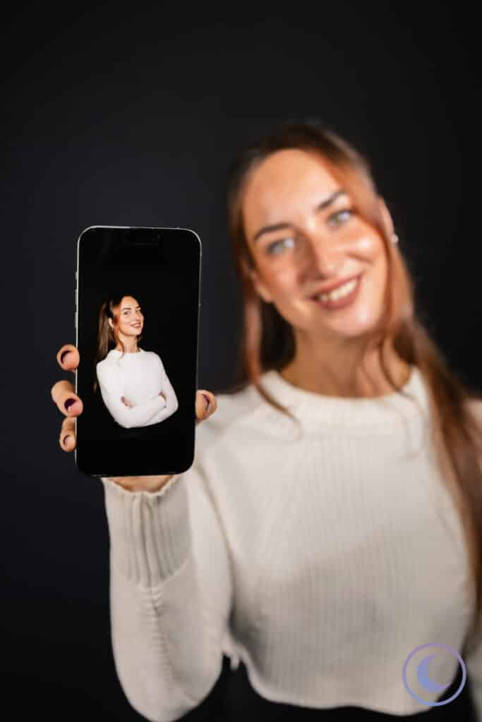 Woman holding smartphone showing her professional headshot taken with Luna Events Headshot Booth in Modesto CA
