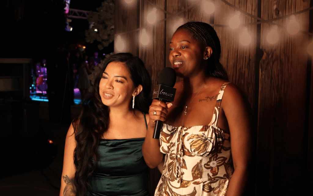 Two wedding guests recording a fun and heartfelt video message inside the Luna Events Confessional Booth